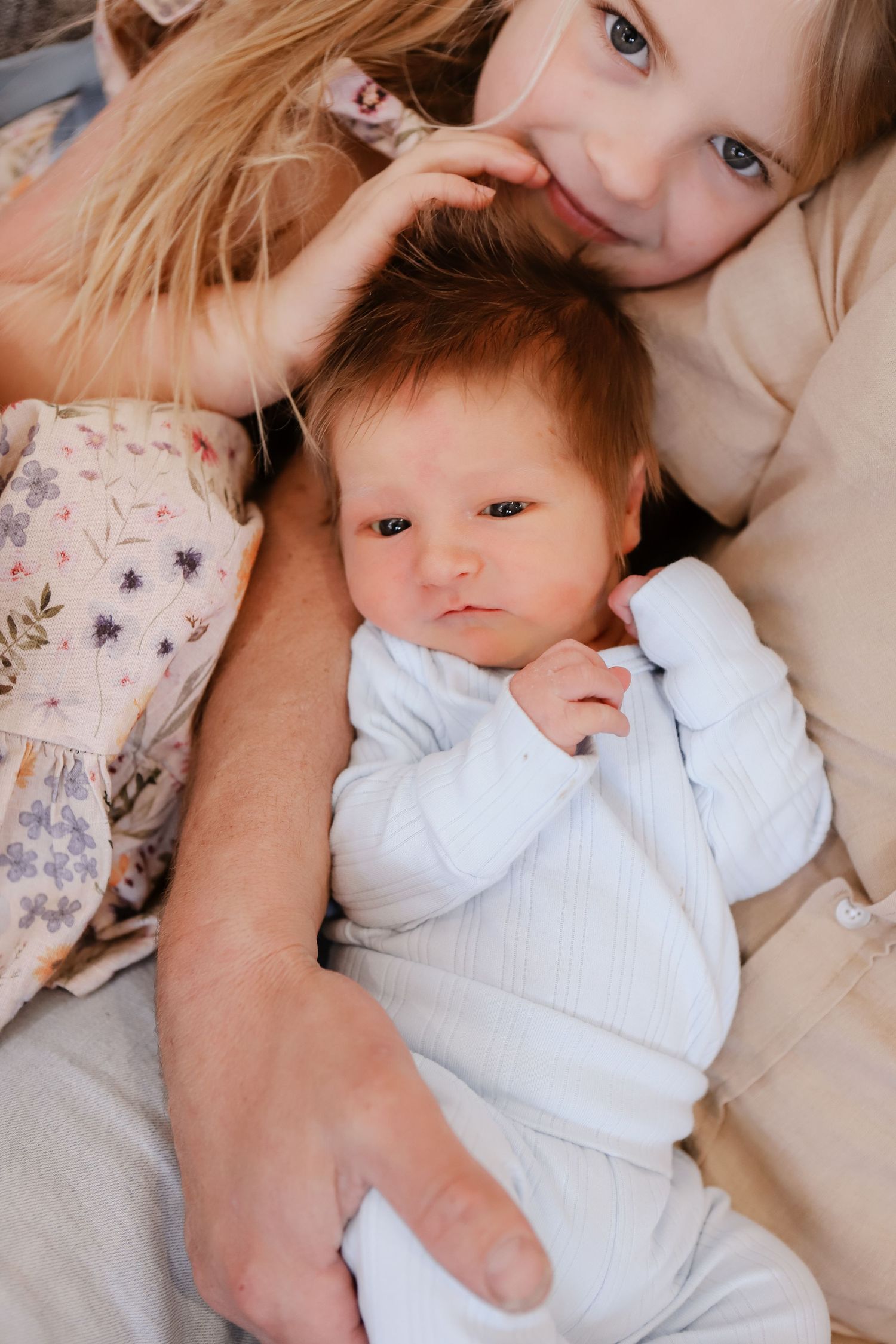 Heartwarming sequence of tender moments between a caregiver and infant in white clothing on cozy beige bedding.