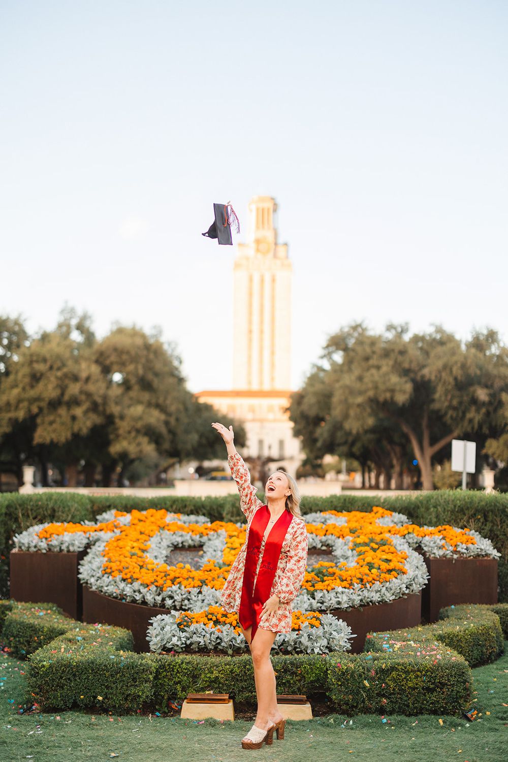 Cheerful scene on campus with floral gardens and UT Austin tower in the background.