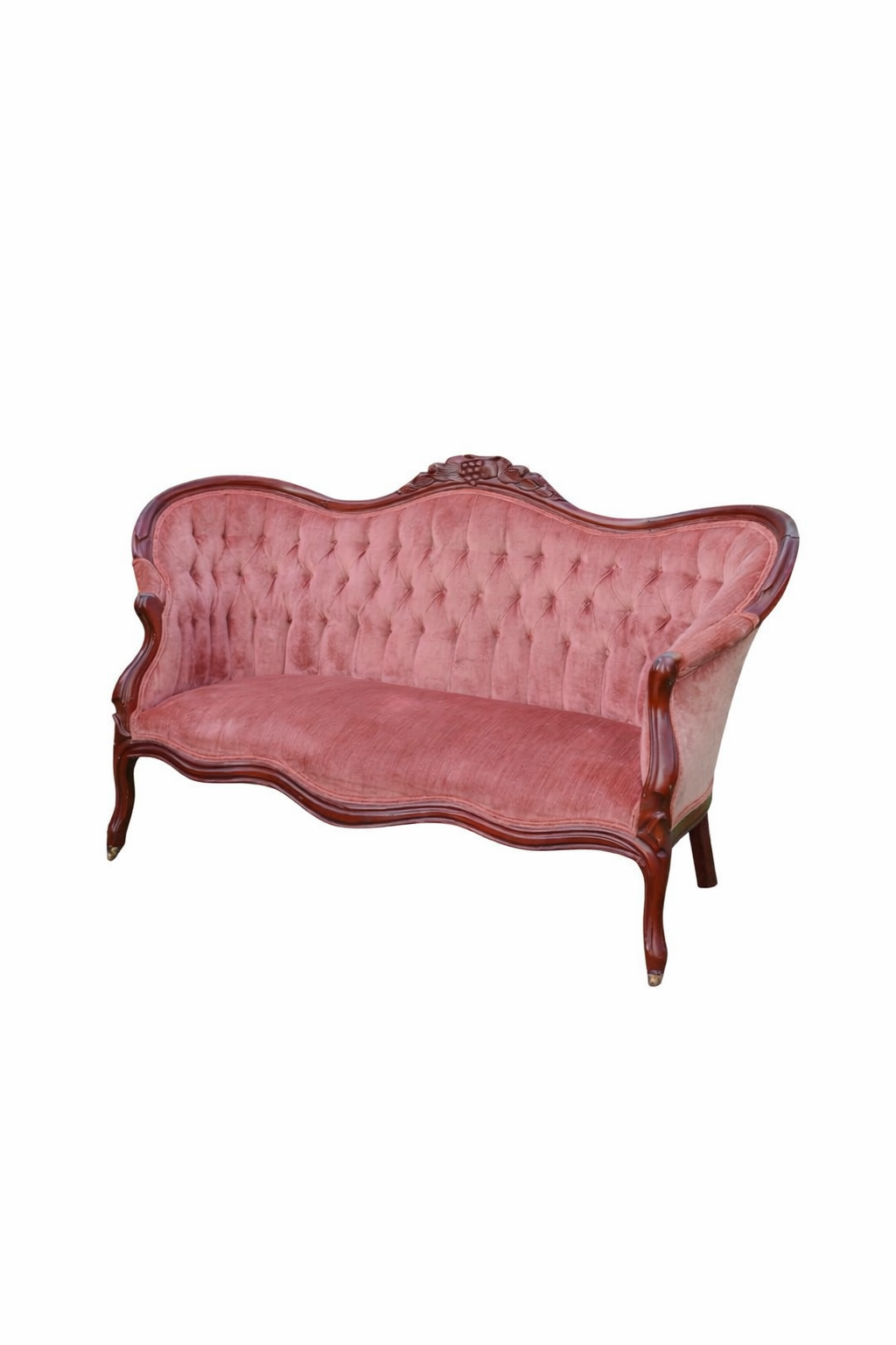 Two vintage red leather armchairs with oval backs sit on grass in a garden setting with trees in the background.