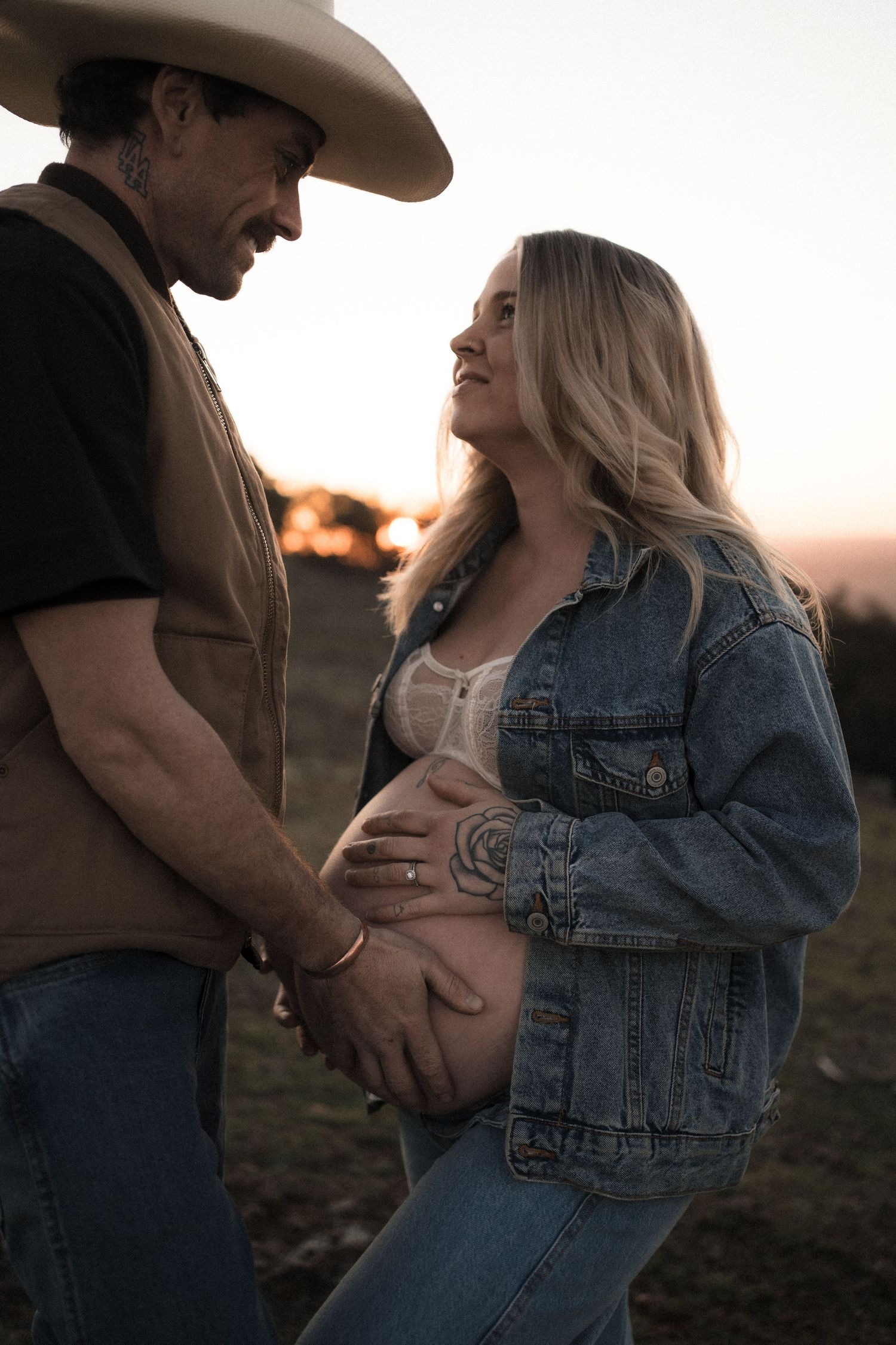 A tender maternity moment between a couple at sunset.
