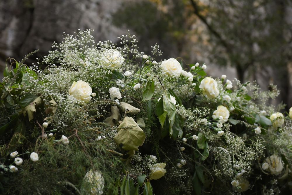 Elegant white rose and baby's breath floral arrangements with green foliage.