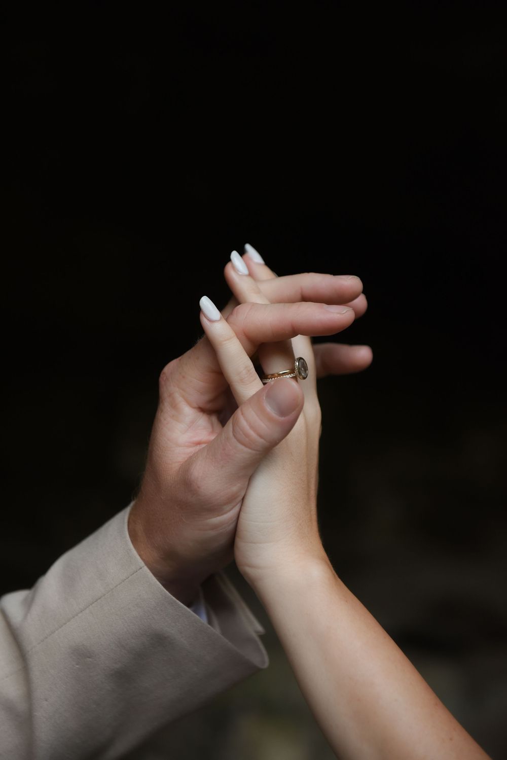 Close-up of hands exchanging wedding rings during a ceremony.