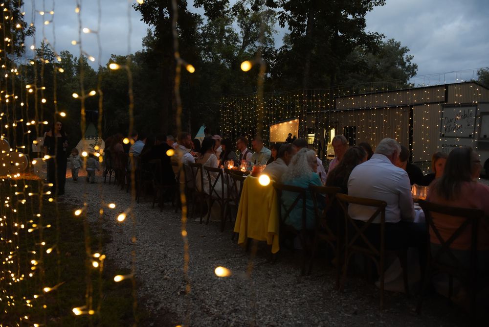 String lights illuminate a wedding celebration, creating a warm and cozy ambiance at night.