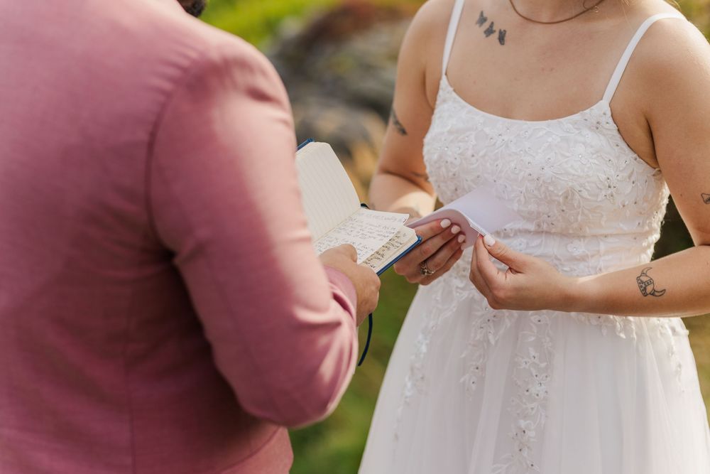 Wedding couple holding hands during sunset ceremony in romantic outdoor garden setting.