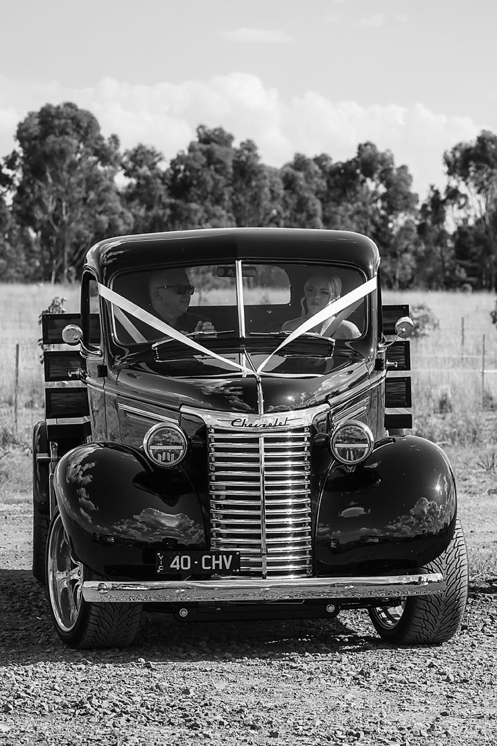 A split view of a vintage black car's front grille and hood shown from different angles on a gravel surface.