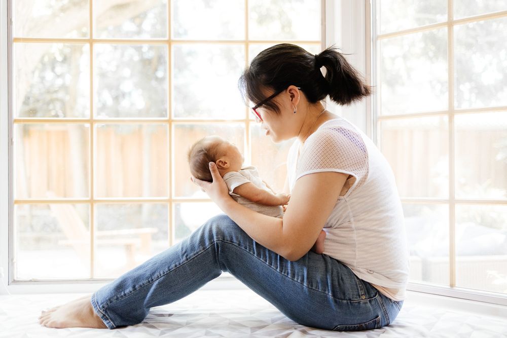 A San Jose mom holds her baby in front of her bay window