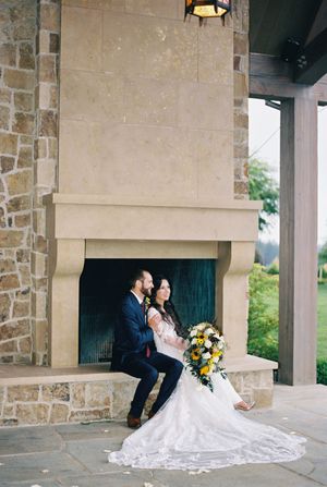 Wedding couple shares intimate moments across stone building exteriors with flowing white dress and yellow bouquet.