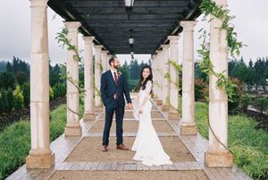 Romantic outdoor wedding ceremony photos taken under an elegant covered walkway with stone columns and floral decorations.