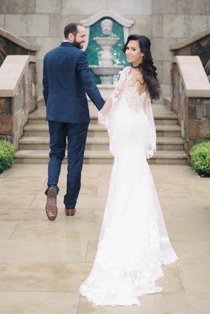 Romantic wedding sequence showing couple walking together across elegant stone terrace with dramatic lighting.
