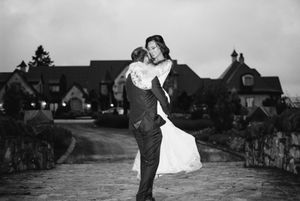 Silhouetted couple spins and dances together outdoors against a cloudy sky backdrop.