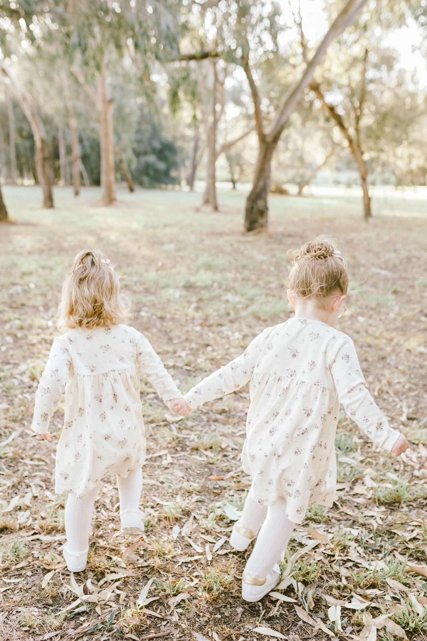 Multiple captures showing someone wearing a delicate white lace dress twirling in a sunlit forest setting.