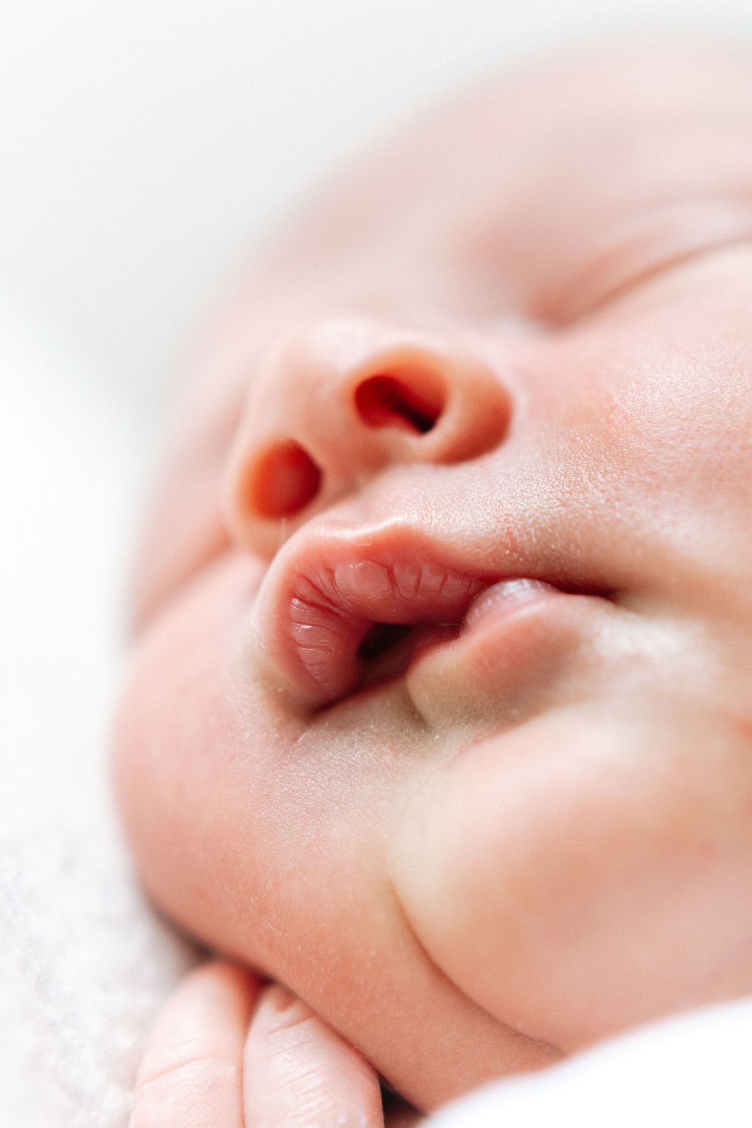 Close-up view of newborn baby's nose and mouth in soft natural light highlighting delicate features, during newborn shoot in Nottingham