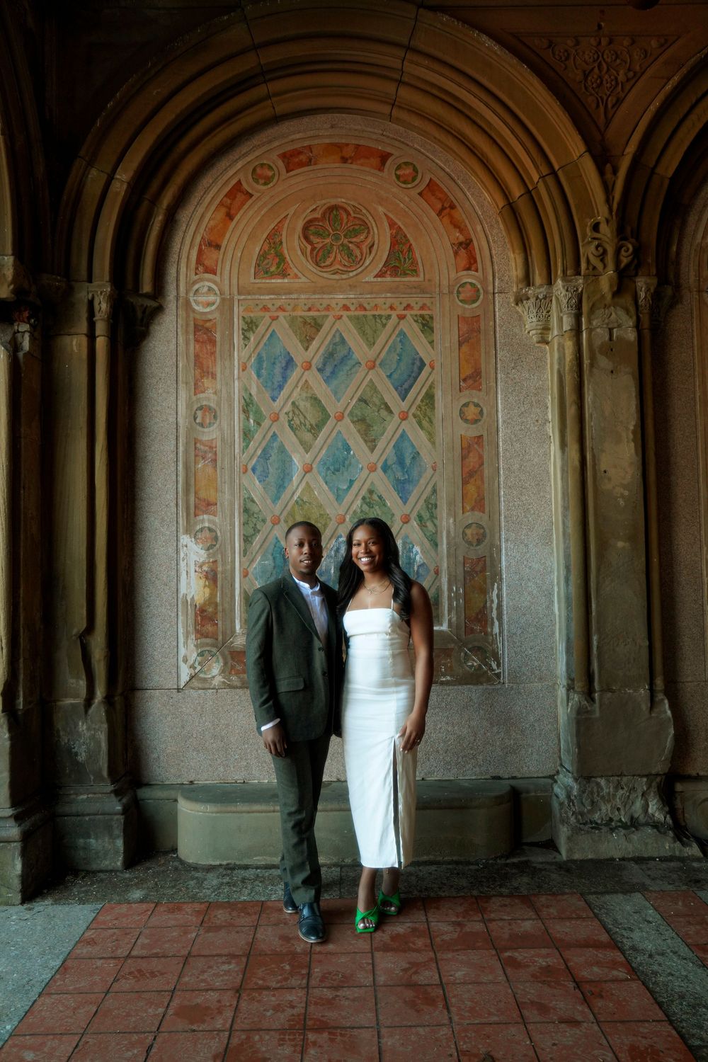 Panoramic view of people standing in a historic ornate passageway with decorated arches and murals. Bethesda Terrace