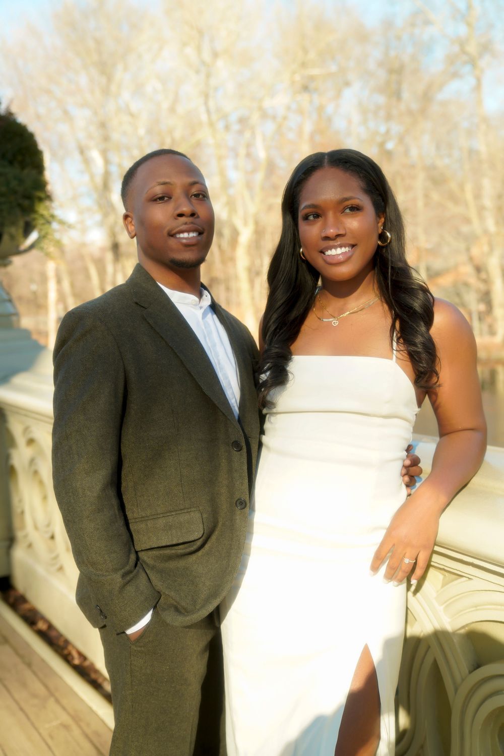 A couple in wedding attire poses together outdoors in a series of romantic photos with trees in the background. central park