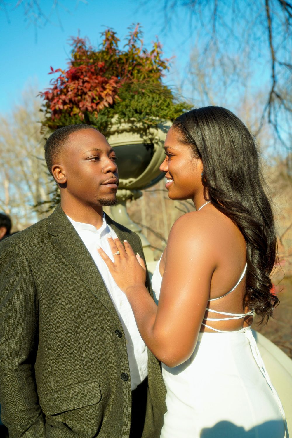 A couple shares intimate moments in an outdoor setting during a fall photo session against a natural background. central park