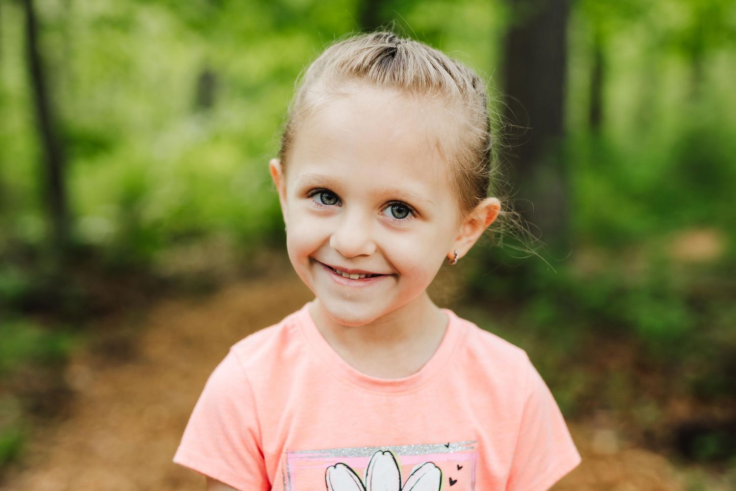 Four connected photos showing someone in a coral colored t-shirt enjoying time outdoors in a wooded setting.