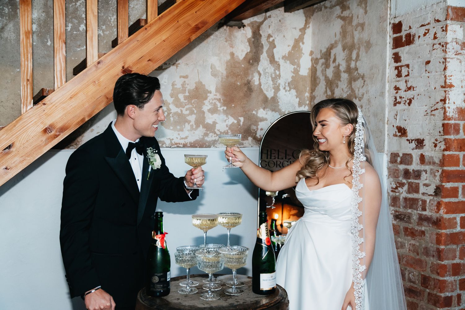 Wedding couple sharing an intimate moment against an exposed brick wall backdrop.
