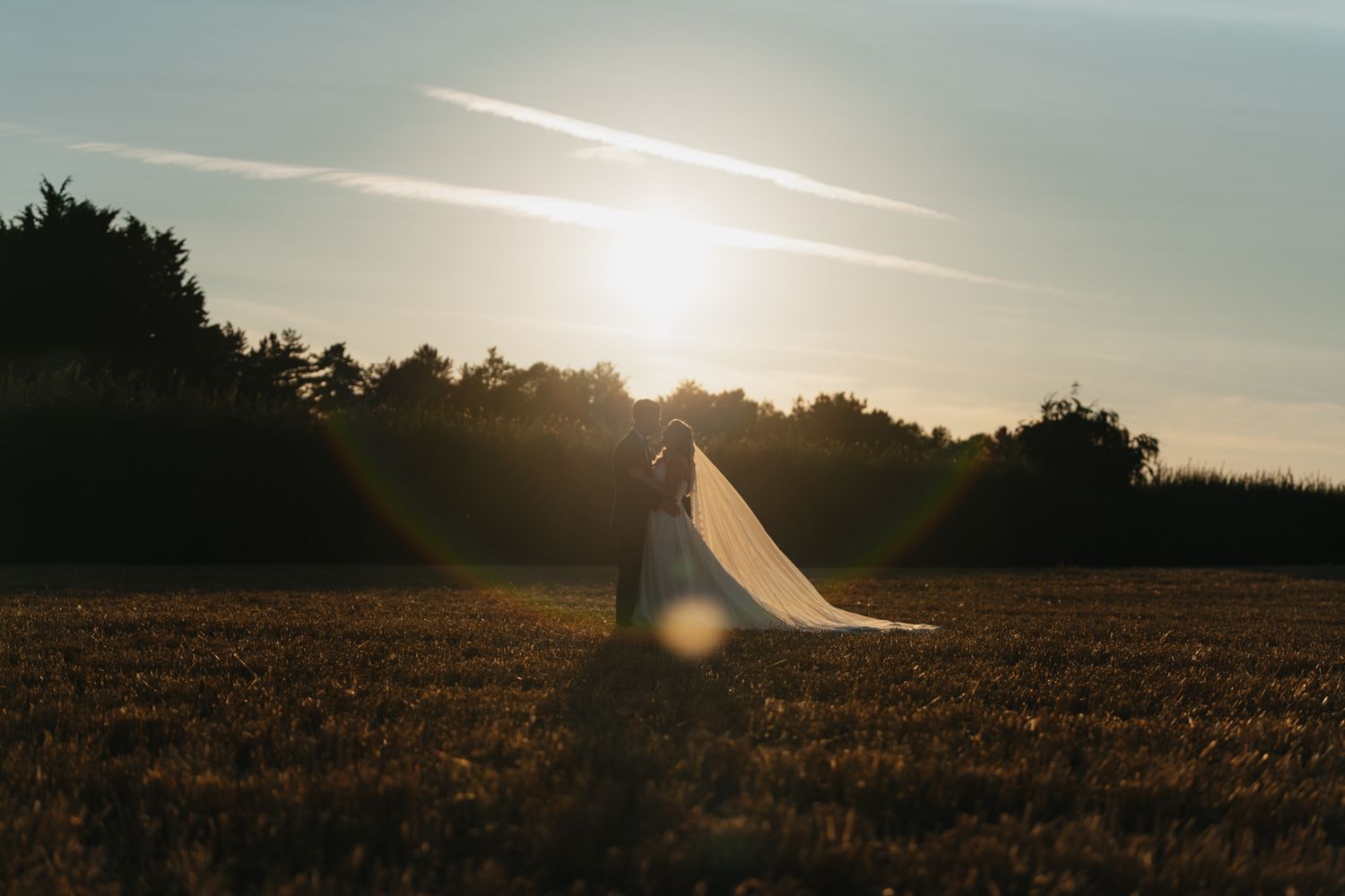 Sunset landscape with golden light streaming across an empty field.