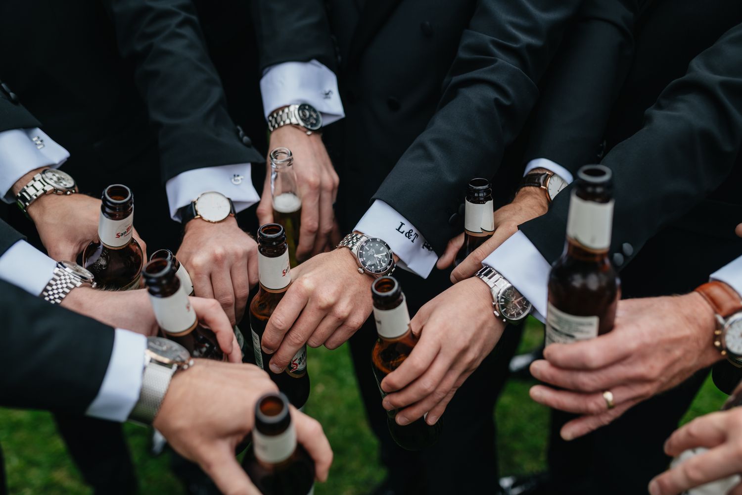 A group of hands with matching watches synchronized together in a circle.