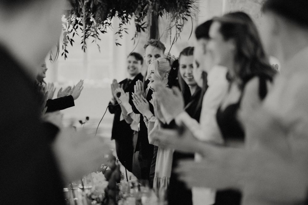 Candid moments captured during an indoor celebration with decorative greenery.