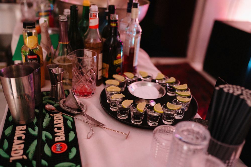 Dessert table with circular platters of treats under pink ambient lighting.