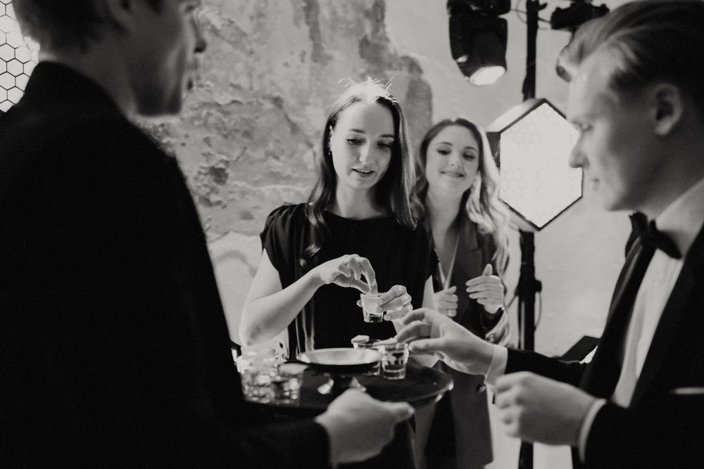 Black and white image of guests enjoying refreshments at a social gathering.