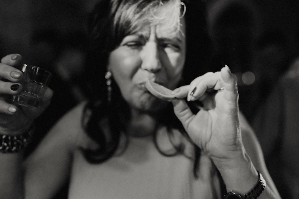 Dark, intimate lighting captures candid moments at an evening celebration.