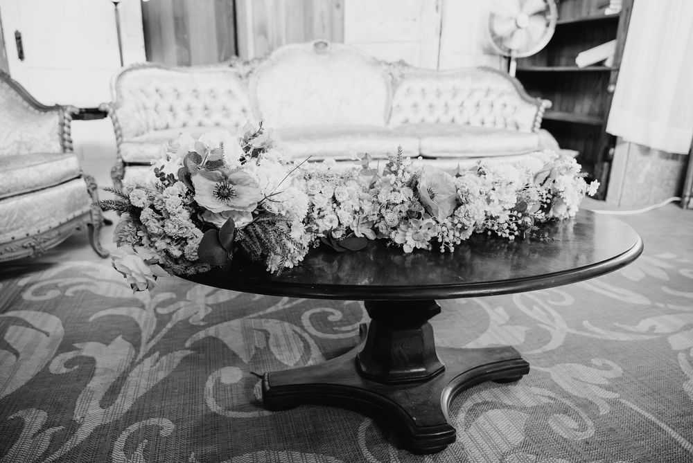 A black and white panoramic collection of desserts and cakes displayed on elegant cake stands and serving platters.