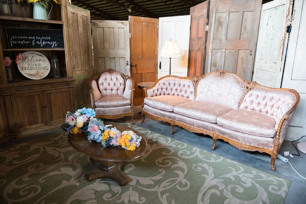 A set of vintage pink tufted Victorian style sofas arranged in an elegant home interior space.