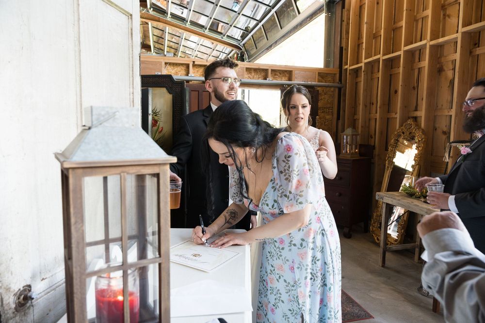 Wedding couple dancing in rustic wooden barn during reception celebration.