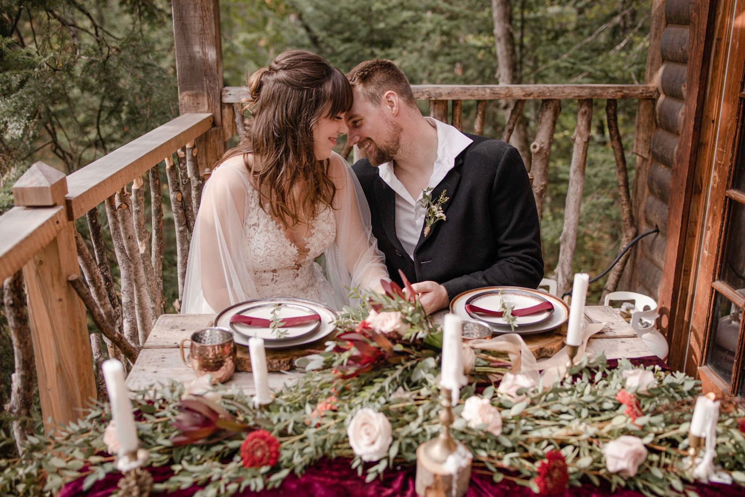 An eloping couple celebrate their ceremony with a lavishly set table: dinner wear, flowers, candles. They laugh. Mont Tremblant, Quebec, CA