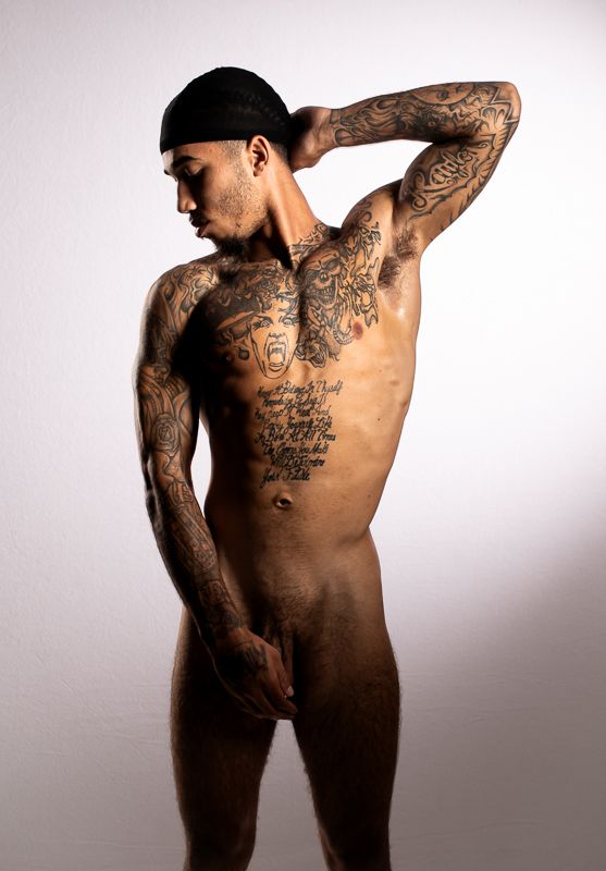 Artistic nude photography series showing tattooed figure against white background.