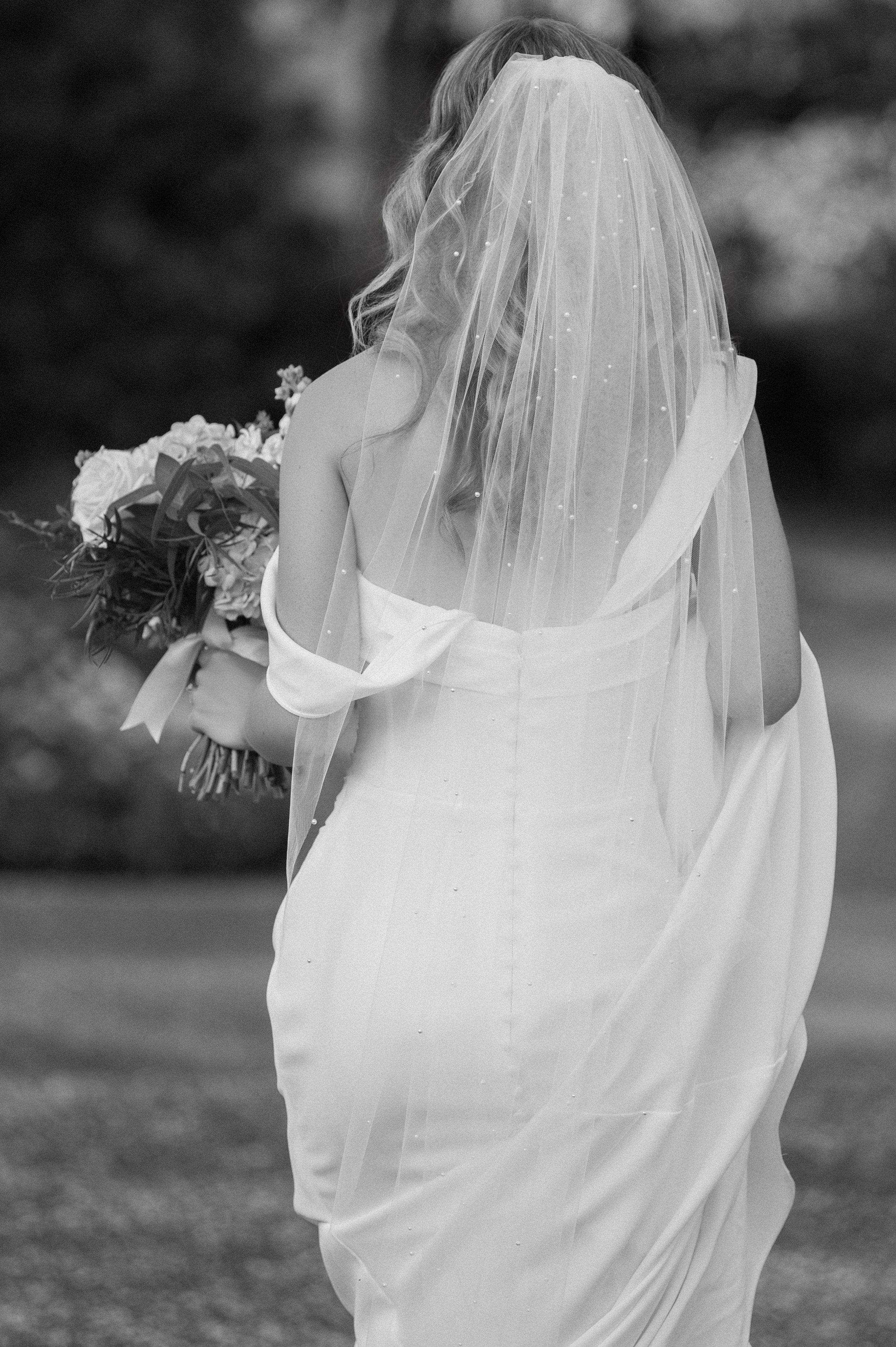 Ethereal black and white bridal portraits showing flowing veil and bouquet details.