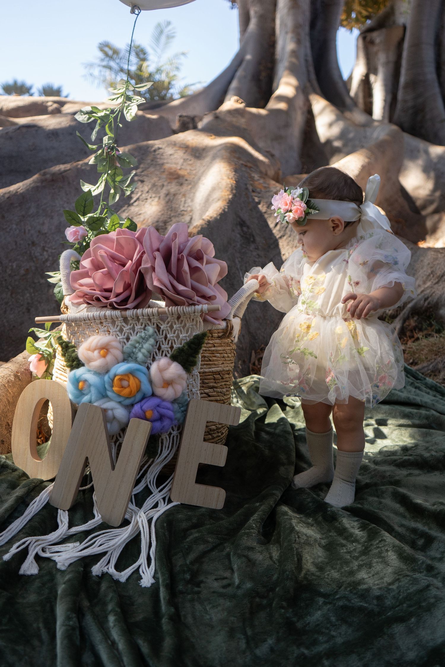 Decorative floral letters spell out LOVE with delicate pink and white flowers against a natural backdrop.