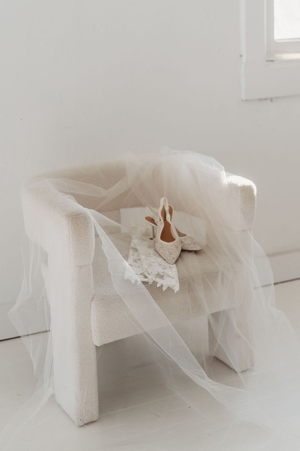 A series of white tulle and fabric swatches arranged in a minimalist composition against a light background.