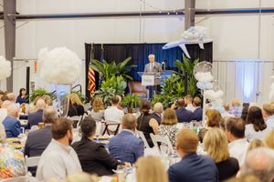 Large conference room setup with rows of chairs facing a stage area for a business presentation.