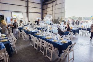 Venue with navy blue tablecloths and white chairs.