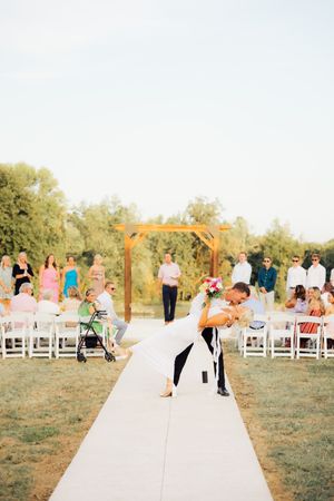 Wedding ceremony rehearsal with guests seated on both sides.