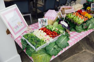 Farm-themed party display with colorful vegetables and decorative fencing.