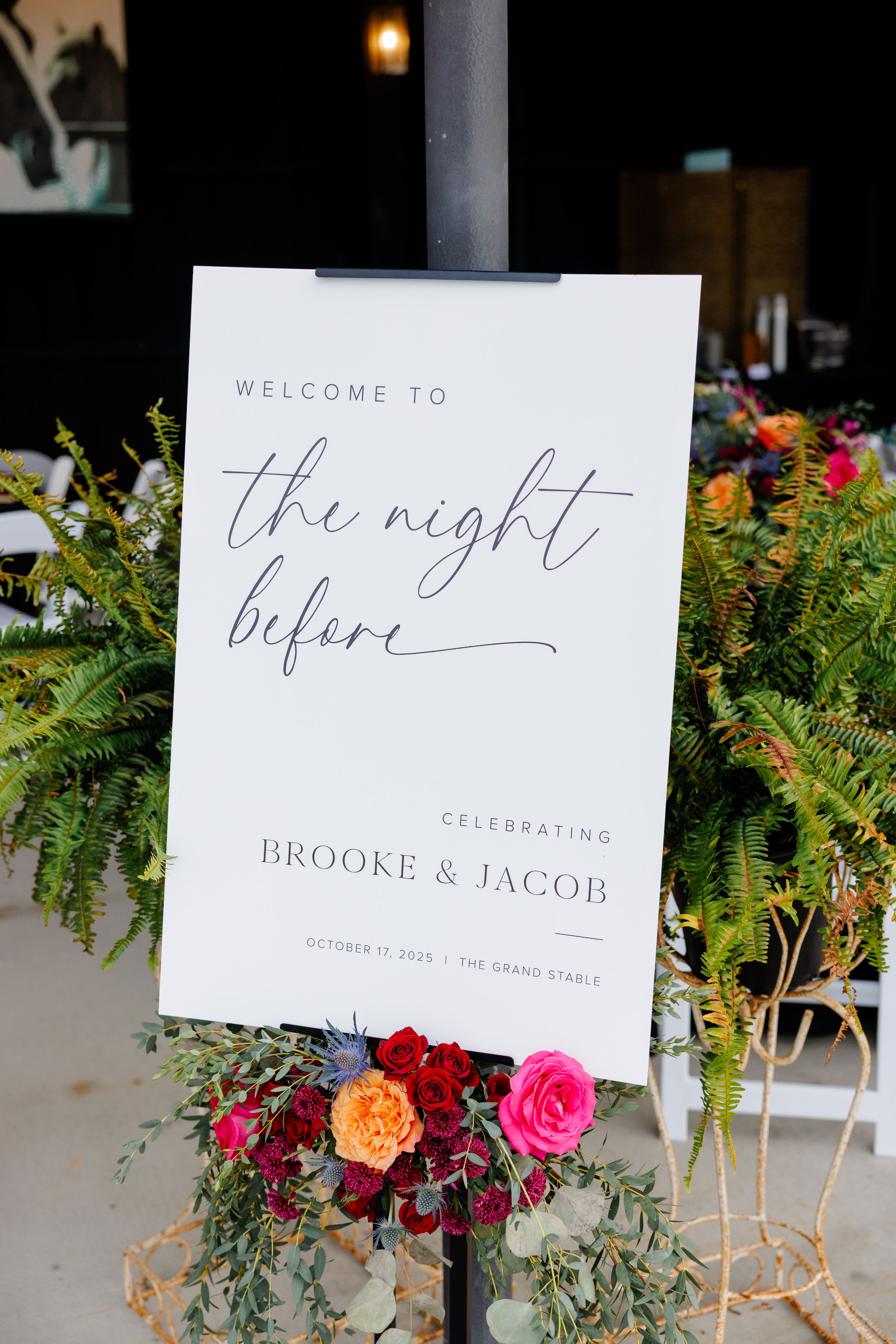 Wedding rehearsal welcome sign with floral decorations for Brooke and Jacob's celebration.
