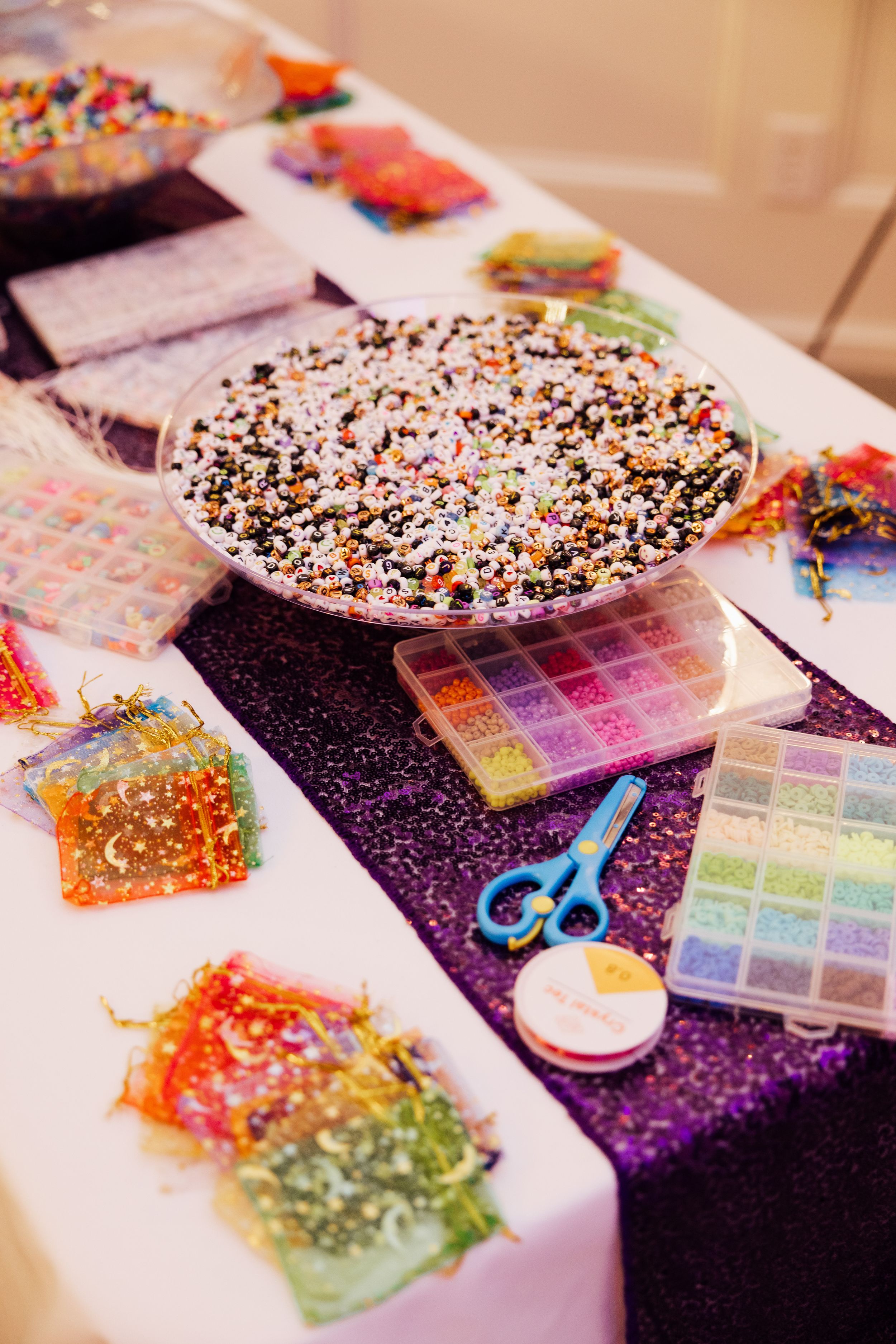 Branding and event session with colorful sprinkle-covered desserts and craft supplies on purple glitter table runner.