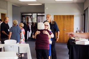 People mingling in an office hallway during a professional networking event.