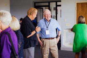 Business casual attendees networking in a conference room setting.