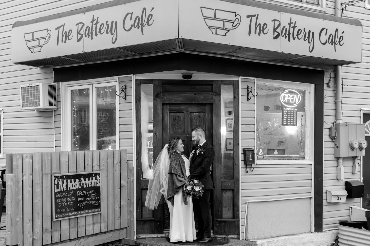 A vintage black and white photo shows the exterior of The Battery Cafe with people standing in the doorway.