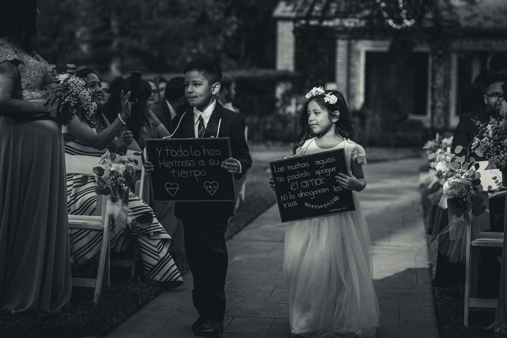 Wedding party members in formal attire gather for candid black and white photos.