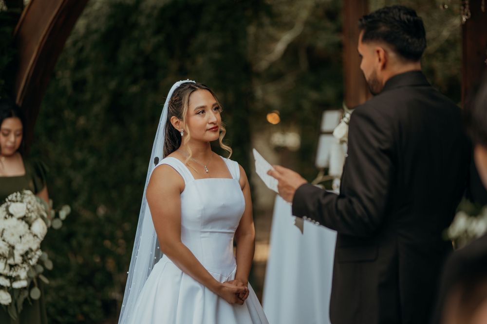 Tender moment captured during a wedding ceremony with guests looking on in the background.