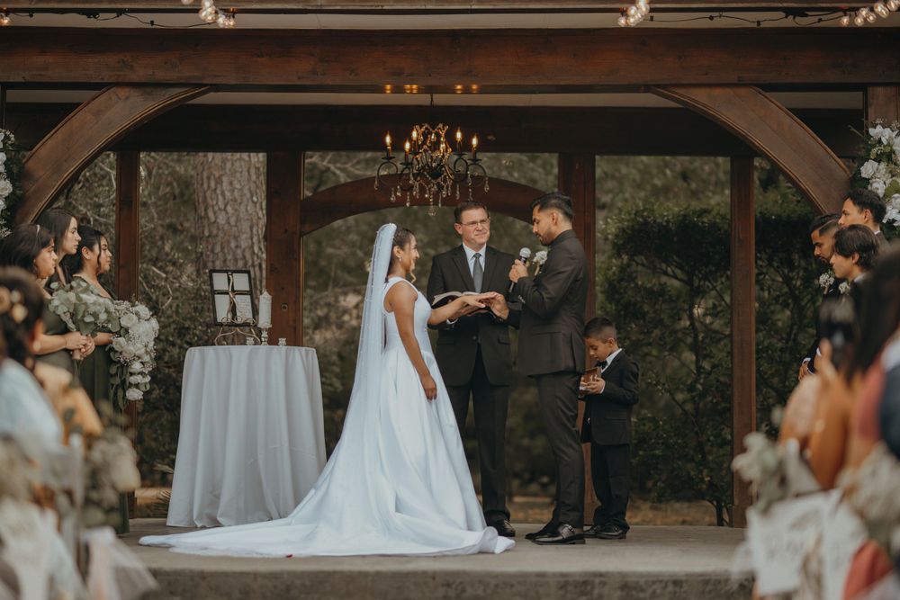 Wedding ceremony venue decorated with string lights and elegant white decor elements.