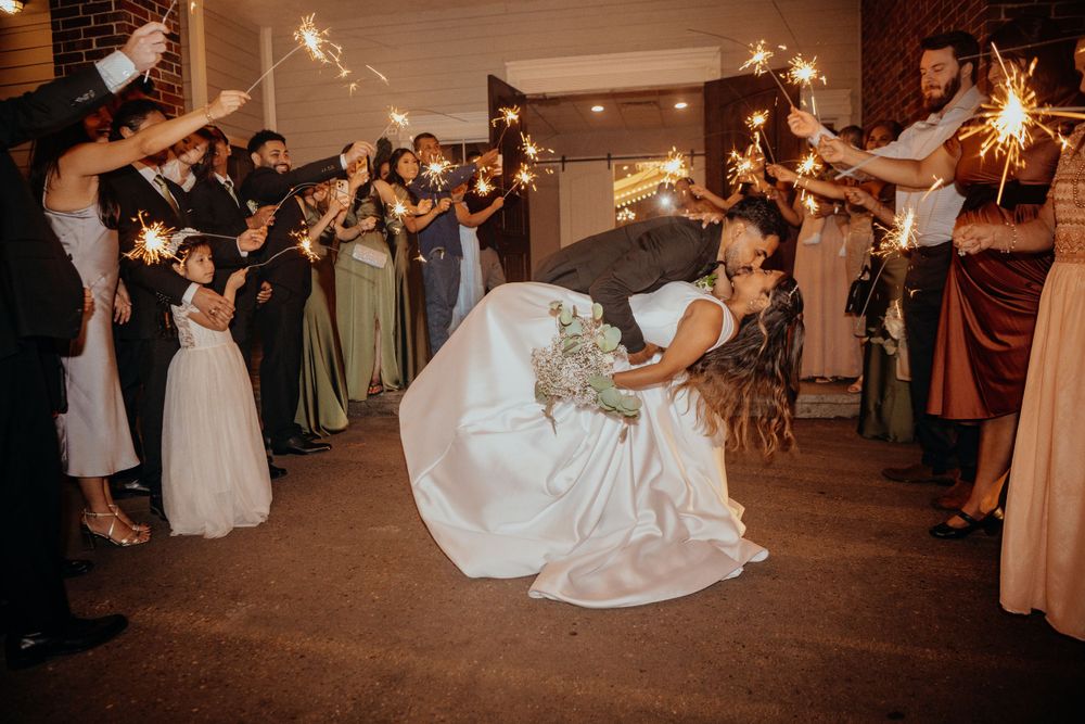 Wedding guests holding sparklers during an evening reception celebration.