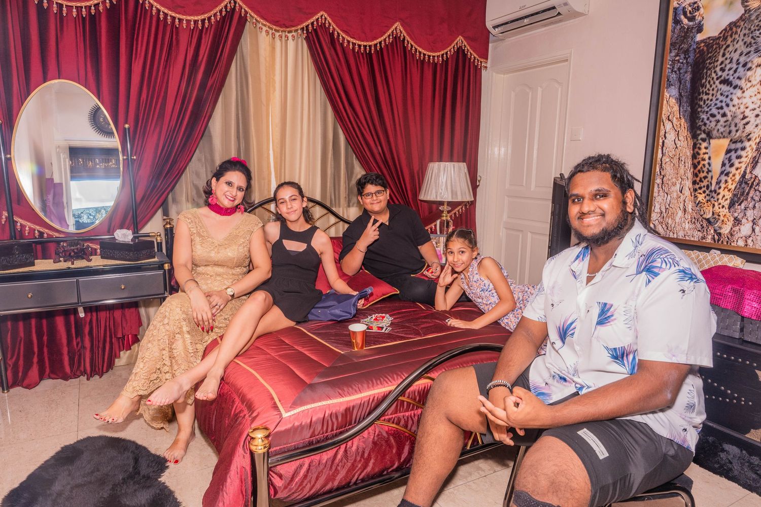 Group relaxing on red decorative couch at indoor party venue.