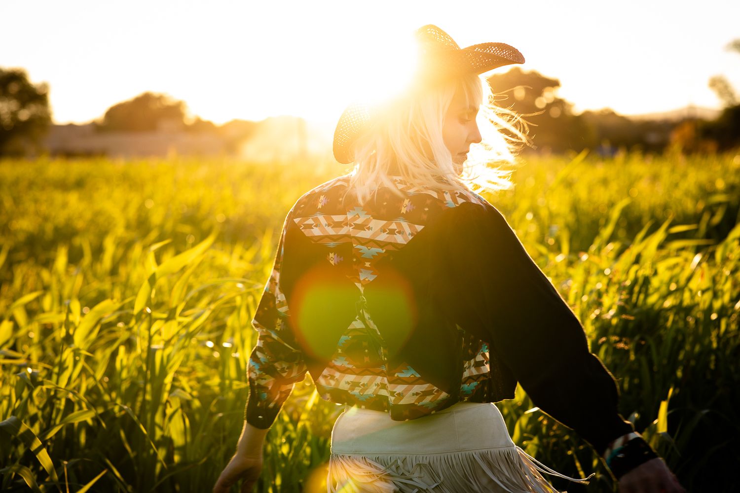 Beautiful outdoor portrait photography; woman in western fashion in field at sunset; Clarissa Anello
